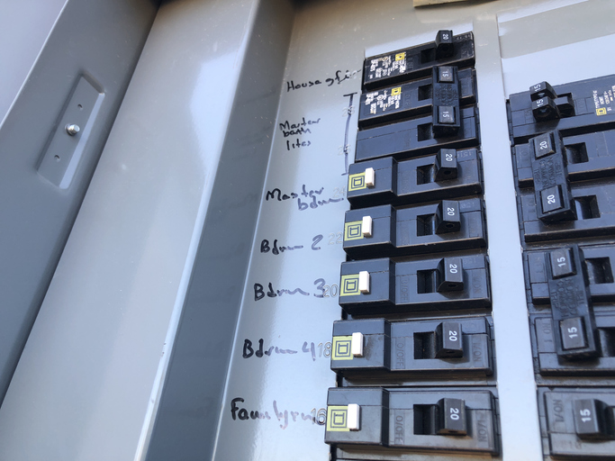 Tampa electricians inspecting a residential fuse box